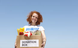 Volunteer carrying food donation box